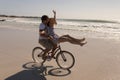 Beautiful happy young woman sitting on man bicycle handlebars