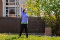 A beautiful happy young woman in sports clothes is doing sports in the yard, doing stretching. Concept of outdoor sports Royalty Free Stock Photo
