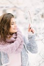 Beautiful happy young woman in a vintage fashion blue sweater and warm scarf walking in the winter city, standing near Royalty Free Stock Photo