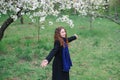 Beautiful happy young woman walking in a blossoming spring garden Royalty Free Stock Photo