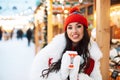 Beautiful happy young woman in winter clothes at christmas market drinking coffee Royalty Free Stock Photo