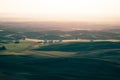 Beautiful hazy sunset from Steptoe Butte in the Palouse of Washington State, with shadows on the rolling hills of farmland