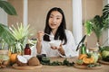 Beautiful healthy asian woman mixing the mass in a bowl while preparing cream.