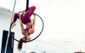 Beautiful healthy strong woman wearing sport bra, relaxing, exercise yoga fly in air, aerial hoop on outdoor rooftop in morning. Royalty Free Stock Photo