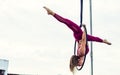 Beautiful healthy strong woman wearing sport bra, relaxing, exercise yoga fly in air, aerial hoop on outdoor rooftop in morning. Royalty Free Stock Photo