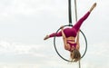 Beautiful healthy strong woman wearing sport bra, relaxing, exercise yoga fly in air, aerial hoop on outdoor rooftop in morning. Royalty Free Stock Photo