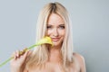 Beautiful healthy woman with blonde hairstyle, clean fresh skin holding summer yellow flower on gray studio background, fashion Royalty Free Stock Photo