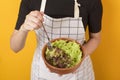 Beautiful healthy woman is eating vegetables on yellow background Royalty Free Stock Photo