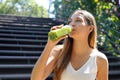 Beautiful healthy young woman drinking green smoothie detox juice outdoors Royalty Free Stock Photo