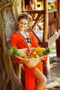 Beautiful healthy young woman is holding basket of tropical frui