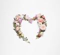 Beautiful heart made of different flowers on white background, top view Royalty Free Stock Photo