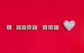 Beautiful heart on red paper background for Valentine`s day. Creative greeting card and wooden cubes with text: Royalty Free Stock Photo