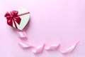 Beautiful heart shaped box with a bow, silk ribbon on a pink background with copy space. Royalty Free Stock Photo