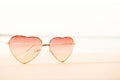 Beautiful heart shaped fashion glasses placed on the beach floor and background sea blur Royalty Free Stock Photo