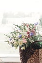 Beautiful herbs wildflowers in wicker bag on rustic white window Royalty Free Stock Photo