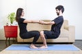 Beautiful hetero caucasian couple in black clothes on blue yogamat doing strength pose