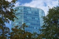 A beautiful high blue glass office building surrounded by trees