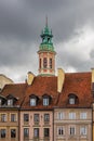 Beautiful high tower of church with cross on top protruding over high and old tenement buildings Royalty Free Stock Photo