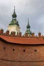 Beautiful high towers of church with cross on top protruding over high old town fortifications