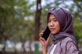 beautiful hijab muslim student calling someone using smartphone in park Royalty Free Stock Photo