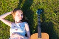 Beautiful hippie girl with guitar lying on grass Royalty Free Stock Photo