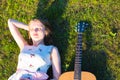 Beautiful hippie girl with guitar lying on grass Royalty Free Stock Photo