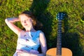 Beautiful hippie girl with guitar lying on grass Royalty Free Stock Photo