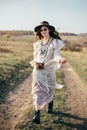 Beautiful hippie girl in hat walking on road in nature Royalty Free Stock Photo