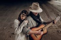 Beautiful hipster couple, handsome cowboy man guitar musician an