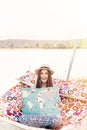 Beautiful hipster girl reading book and relaxing in hammock on the beach in summer evening light. happy woman in straw hat resting Royalty Free Stock Photo