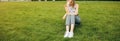 Beautiful hipster girl is sitting near the modern architecture building on the sunny day. Stylish business woman resting on the Royalty Free Stock Photo