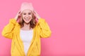 Beautiful hipster teenage girl in bright yellow jacket and pink beanie hat super excited. Attractive cool young woman portrait. Royalty Free Stock Photo