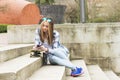 Beautiful hipster urban girl with skateboard and cellphone.