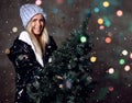 Beautiful hipster woman with Christmas fir tree and lights in knitted sweater blouse Royalty Free Stock Photo