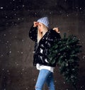 Beautiful hipster woman with Christmas fir tree in knitted sweater blouse and knitted hat Royalty Free Stock Photo