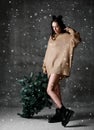 Beautiful hipster woman with Christmas fir tree in knitted sweater blouse under snow Royalty Free Stock Photo