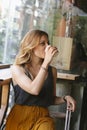 Beautiful hipster woman drinking coffee with a suitcase Royalty Free Stock Photo