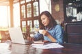 Beautiful hipster woman using laptop at cafe while drinking coffee, Relaxing holiday concept. Royalty Free Stock Photo