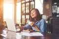 Beautiful hipster woman using laptop at cafe while drinking coffee, Relaxing holiday concept. Royalty Free Stock Photo