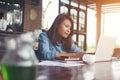 Beautiful hipster woman using laptop at cafe while drinking coffee, Relaxing holiday concept. Royalty Free Stock Photo