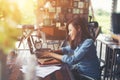 Beautiful hipster woman using laptop at cafe while drinking coffee, Relaxing holiday concept. Royalty Free Stock Photo