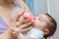 Beautiful Hispanic baby making an obscene gesture with her middle finger, while taking her bottle Royalty Free Stock Photo