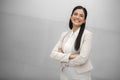 Beautiful hispanic business woman, executive, boss, CEO, entrepreneur in a suit, smiling and standing confidently with arms crosse Royalty Free Stock Photo