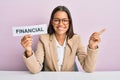 Beautiful hispanic business woman holding financial message paper smiling happy pointing with hand and finger to the side Royalty Free Stock Photo