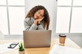 Beautiful hispanic business woman sitting on desk at office working with laptop sleeping tired dreaming and posing with hands Royalty Free Stock Photo