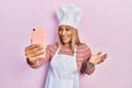 Beautiful hispanic cook woman taking a selfie photo with smartphone celebrating achievement with happy smile and winner expression Royalty Free Stock Photo