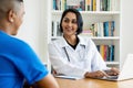 Beautiful hispanic female doctor talking with healthy patient