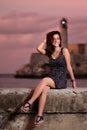 Beautiful hispanic girl sitting on the Malecon seawall at sunset in Havana Royalty Free Stock Photo