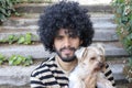 Beautiful Hispanic man with curly hairstyle holding Yorkshire terrier dog Royalty Free Stock Photo