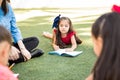 Hispanic preschool girl writing outdoors